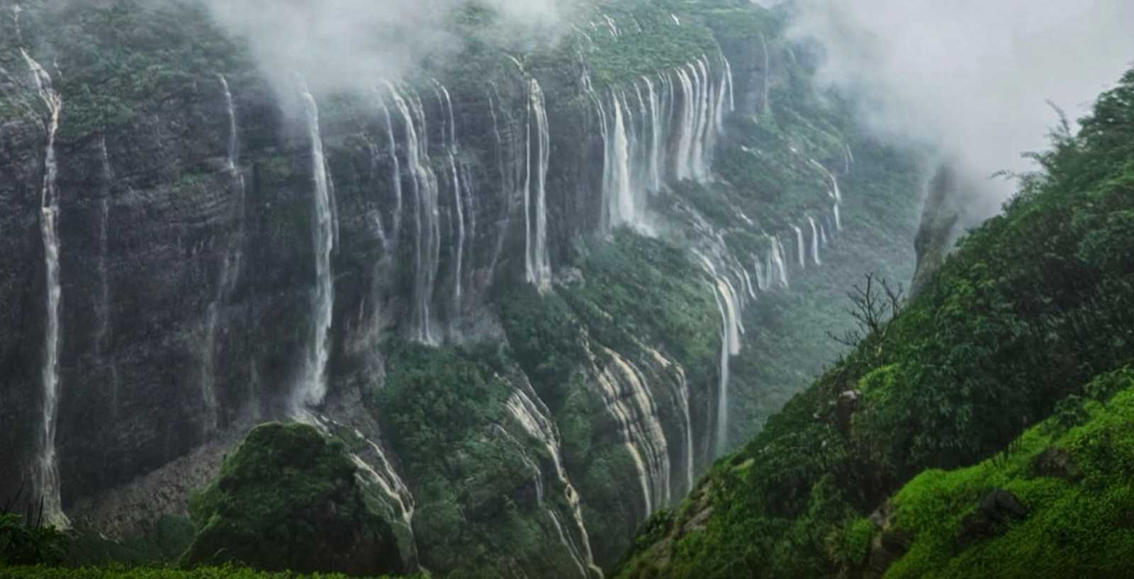 Waterfalls pouring off misty Sahyadri cliffs at Andharban in the monsoon